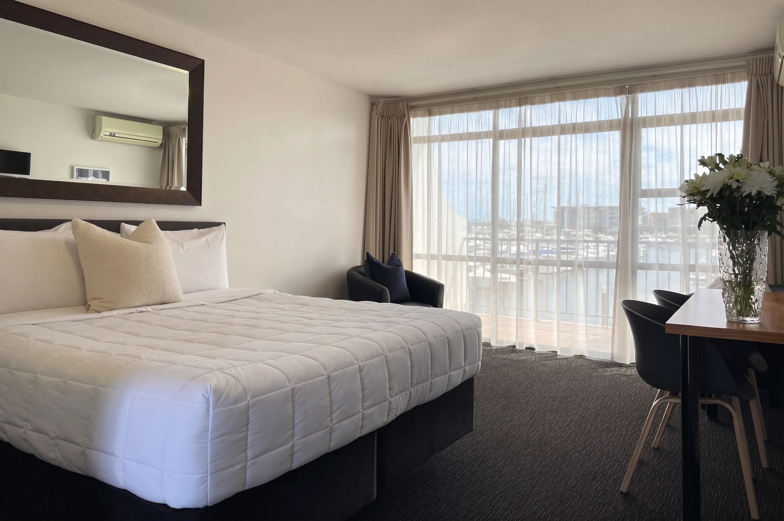 A middle-floor Superior Studio with a King bed and marina views through floor-to-ceiling glass